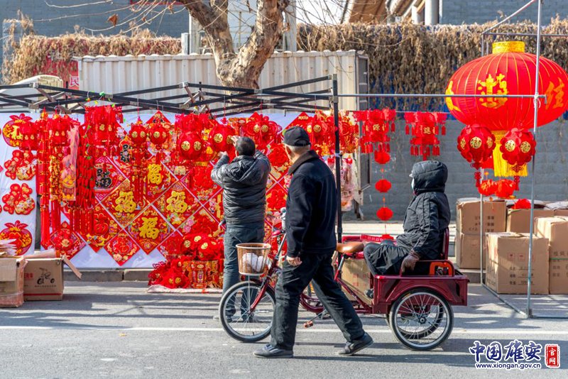 農(nóng)歷臘月二十三，北方“小年”至，過年模式正式開啟。雄安新區(qū)容城縣街頭，行人駐足觀看滿街的燈籠、春聯(lián)，感受濃濃年味。中國雄安官網(wǎng)記者馬夢迪 攝
